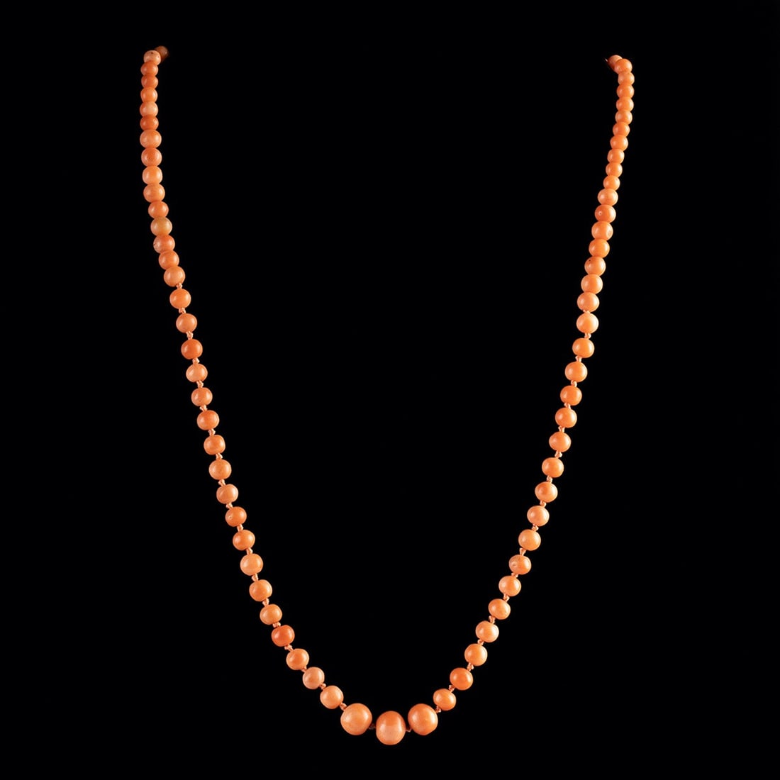 Victorian Coral Graduated Bead Necklace with Brass Clasp: Europe, Victorian to Edwardian era, ca. late 19th - early 20th century CE. A single strand of Mediterranean coral beads, polished to a soft glow and graduated from small spheres at the nape to larger 