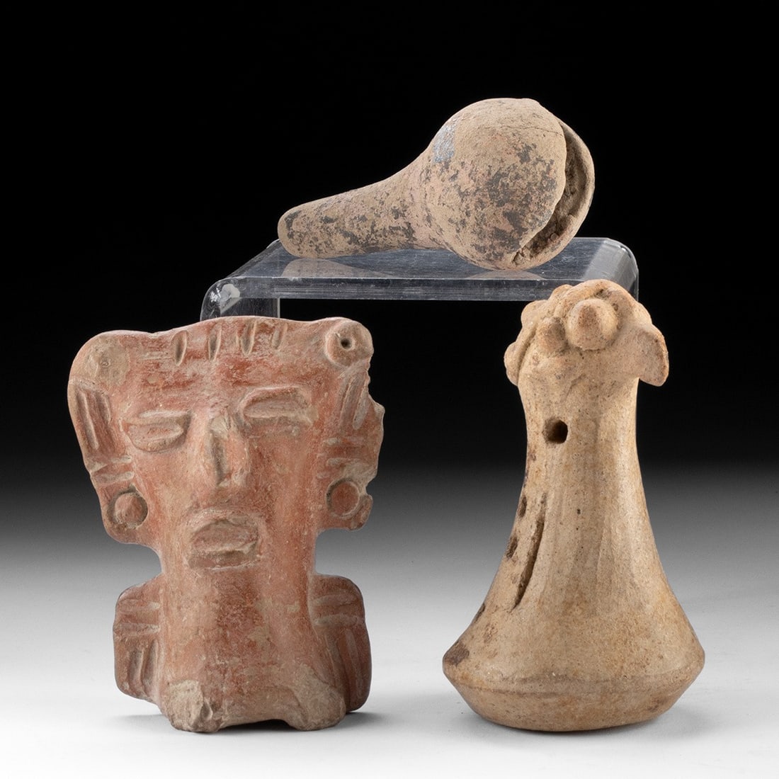 Three Ancient Mesoamerican Ceramic Rattles: Pre-Columbian, Mexico & Costa Rica, ca. 300 BCE to 1500 CE. Three pottery rattles: a pestle-shaped rattle in the form of a bird; a seated figure with oversized head and earspools; and a simple crotal 