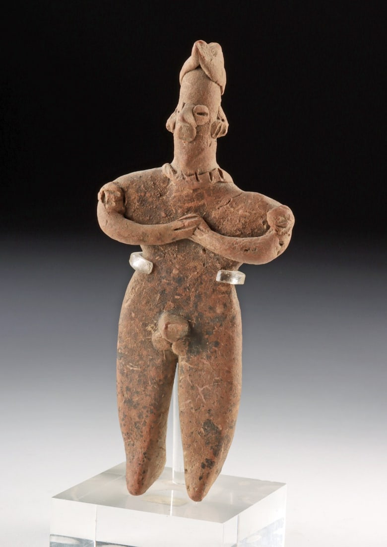 Colima Pottery Male Figure, Headdress & Jewelry, West Mexico: Pre-Columbian, West Mexico, Colima, ca. 300 BCE to 300 CE. A pottery figure depicting a nude male standing with legs slightly apart and arms raised across the chest. The figure displays a tall headdre