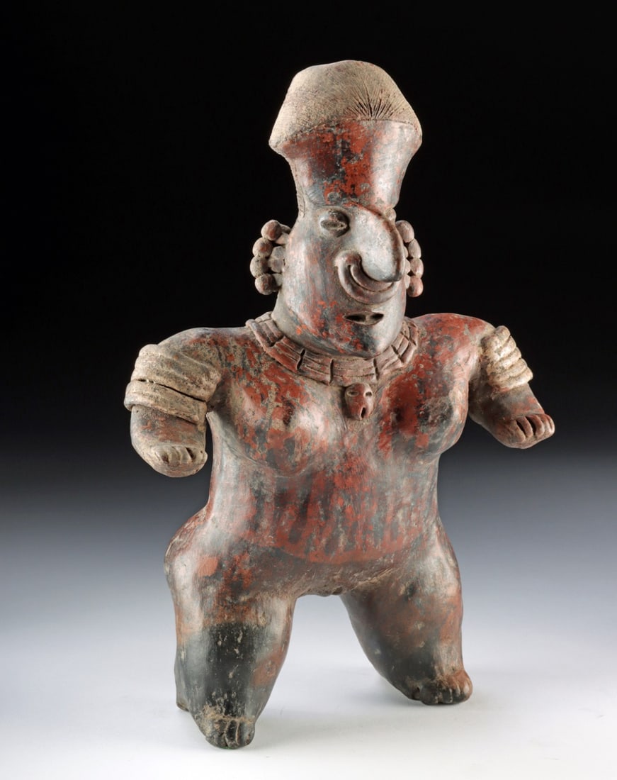 Jalisco Standing Female Pottery Figure: Pre-Columbian, West Mexico, Jalisco, ca. 300 BCE – 300 CE. Pottery nude female figure standing with feet apart, arms held to her sides, ample hips and thighs to indicate fertility, headdress and