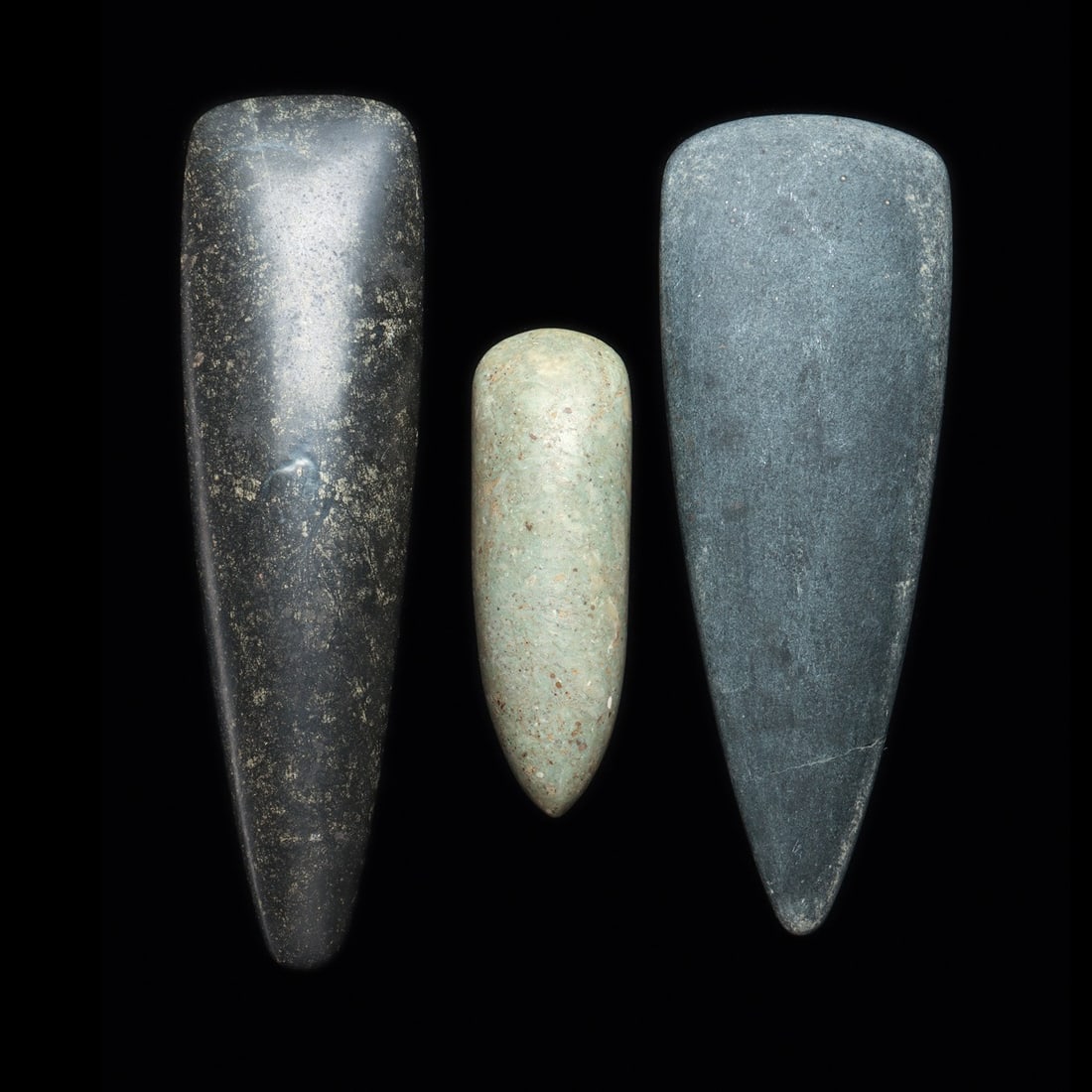 Taino Petaloid Stone Celts (3): Greater Antilles Islands, Caribbean Sea, Hispaniola, taino culture, ca. 1000 to 1500 CE. Three carved stone examples, including a large dark gray hardstone petaloid celt, having a very nice matte surf