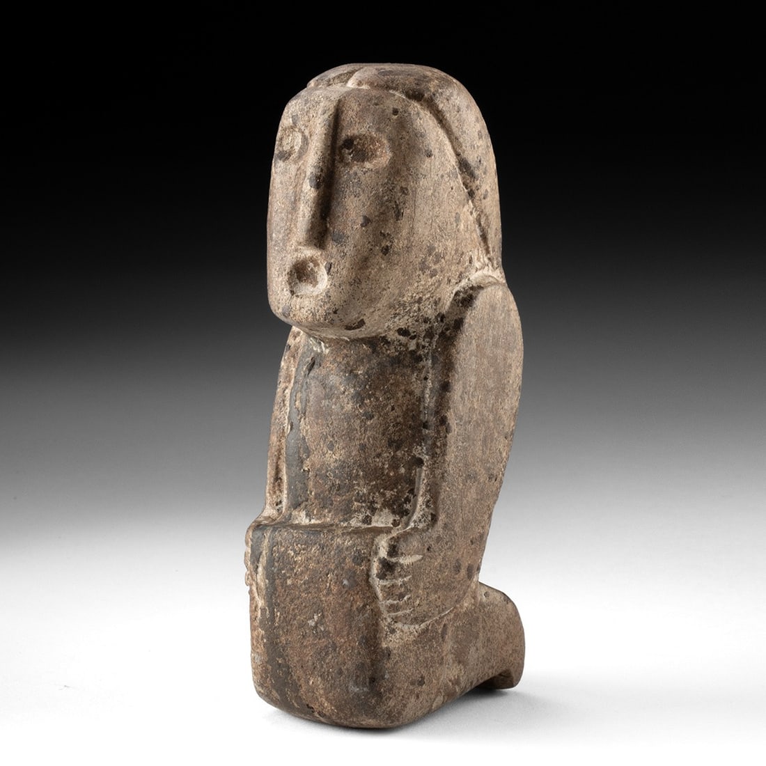 Mississippian Carved Stone Human Effigy Figure - Frontal Face: Native American, Mississippian culture, ca. 1000–1500 CE. A compact human effigy pecked and ground from a dense, weathered stone, its broad face dominating the upper body. The carver reduced the