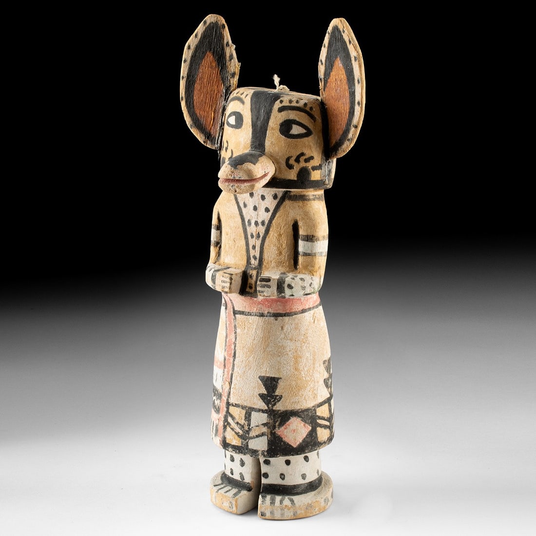 20th C. Hopi Kwewu Wolf Kachina: Native American, Southwestern United States, Hopi, ca. mid-20th century CE. A carved cottonwood kachina figure depicting Kwewu, the wolf spirit, with large triangular ears painted russet and ringed wi