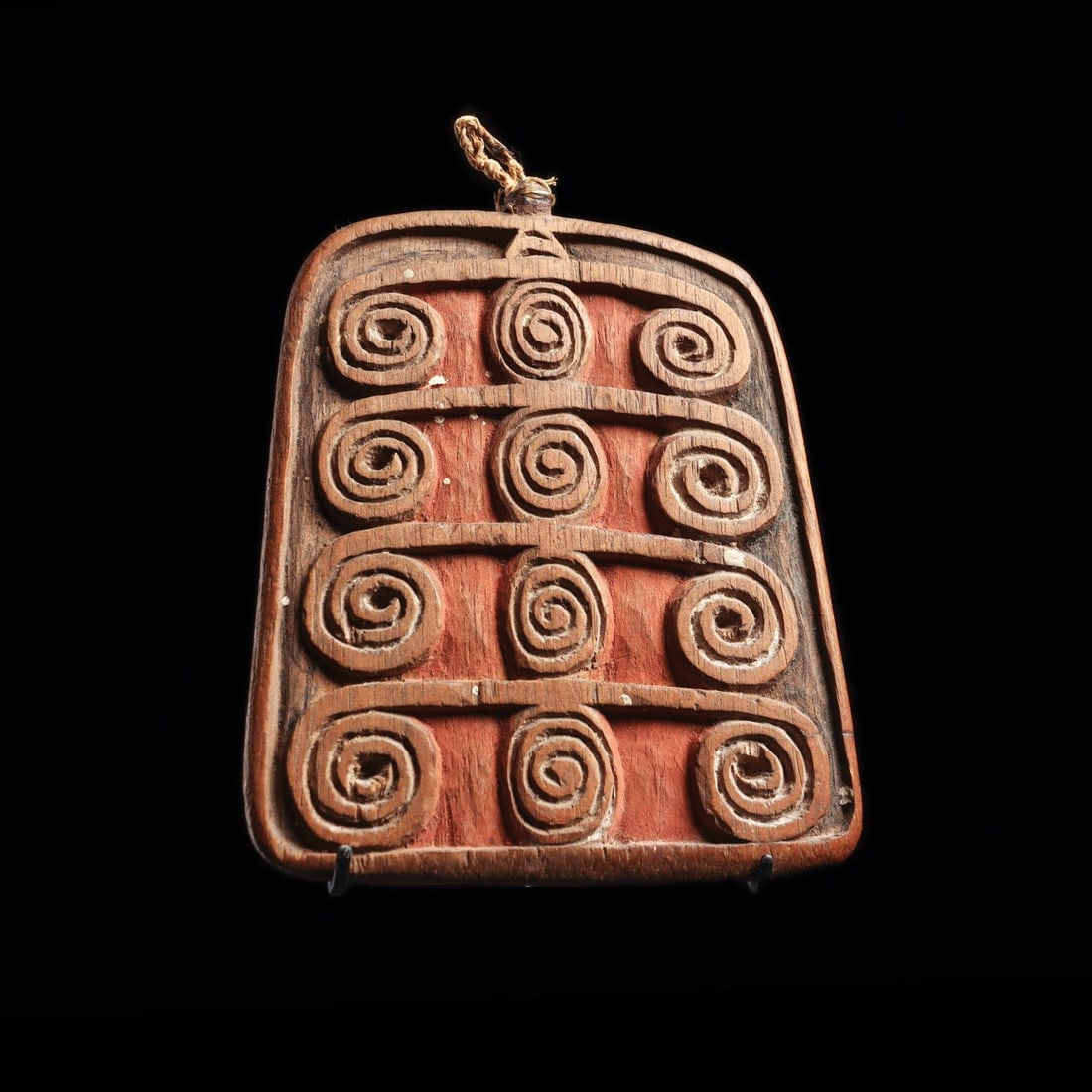 Borneo Spiral Protection Pendant with Ritual Pigment and Bitumen: Borneo, Kenyan tribe, ca. 19th century. Carved wood in a squared palette form, serving as a protective amulet with incised spiral motifs intended to ward off malevolent forces. The surface retains