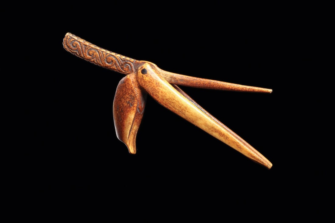 Dayak Tobacco Cigar Roller in Shape of Bird: Borneo, ca. 19th century. Finely carved from bone in the form of a stylized bird. The head is rendered with a long, pointed beak, while the metal hinge serves as the bird's eye and secures the