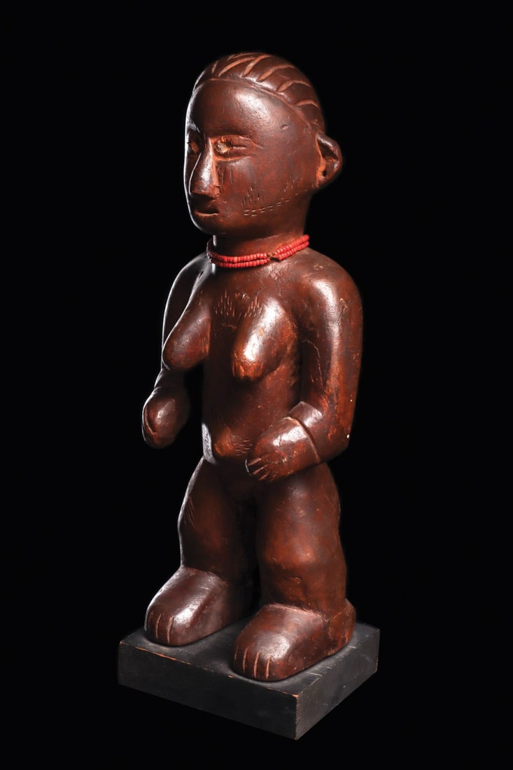 Chamba Female Figure: Nigeria. Carved wood standing figure of naturalistic forms, is adorned with areas of delicate scarification lines along eyebrows, cheeks, across chest, surrounding relief navel. Red glass bead choker 