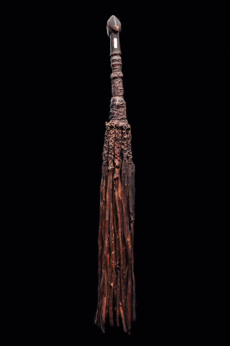 Yoruba Fly Whisk: Nigeria. Carved handle in form of anthropomorphic ancestral head with peaked headdress, wrapped with braided leather strips. Dark brown patina of wood handle. 28.25" L (71.76 cm L). Provenance: Collec