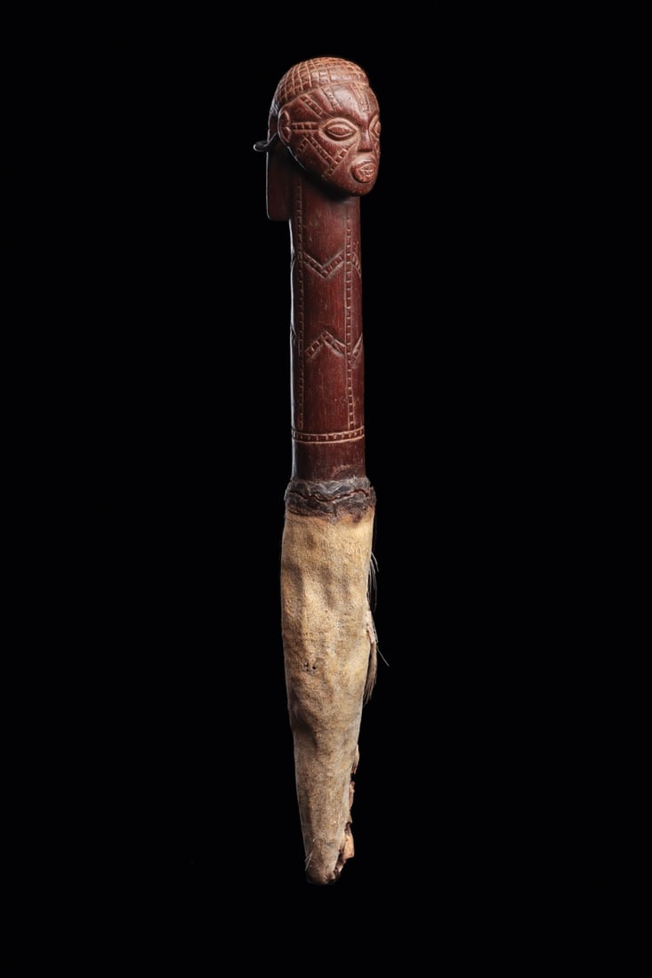 Tabwa Fly Whisk: Democratic Republic of Congo. Prestige object with handle carved with anthropomorphic head and long neck detailed with scarification lines, and hairdo with net pattern. Dark red-brown smooth patina.