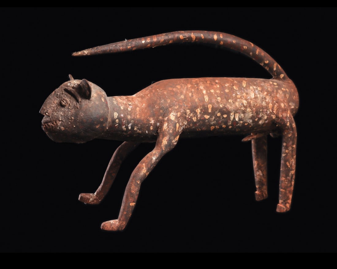Large Leopard: Democratic Republic of Congo. Carved wood stylized leopard from a shrine, freestanding on narrow legs with long extended tail curved above elongated body. Painted with red ochre and white dot