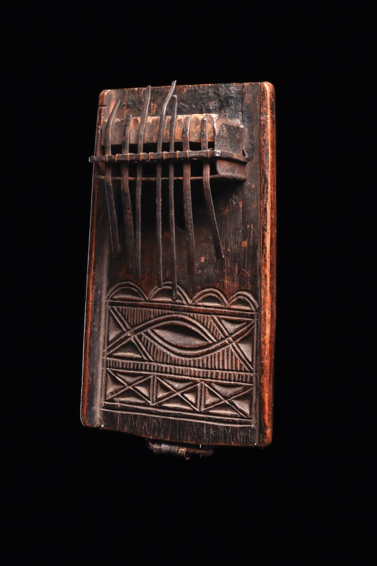 Chokwe Thumb Piano (Mbira or Sanza): Democratic Republic of Congo. Fine tone sanza with seven metal keys supported by rectangular metal alloy and wood resonating box, the rectangular frame engraved with motifs, and twisted band along