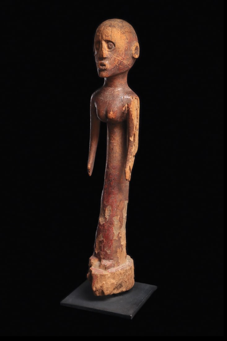 Sukuma Figure: Tanzania. Standing female figure, carved with ovoid head, relief circular ears; torso with rounded breasts and long sweeping slender lower body on integral base. Matte patina, traces of red-brown pigm