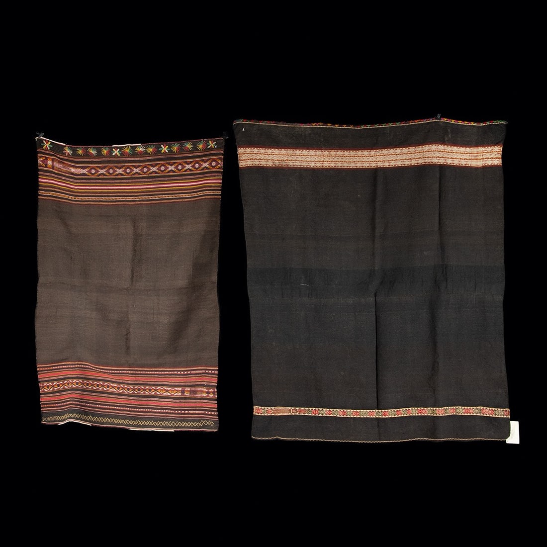 Two Traditional South American Aymara Woven Wool Shawls: South America, Bolivia / Peru, Aymara or Quechua culture, ca. mid to late 20th century CE. A pair of handwoven wool shawls, each with a deep brown to near-black ground framed by bands of patterning in