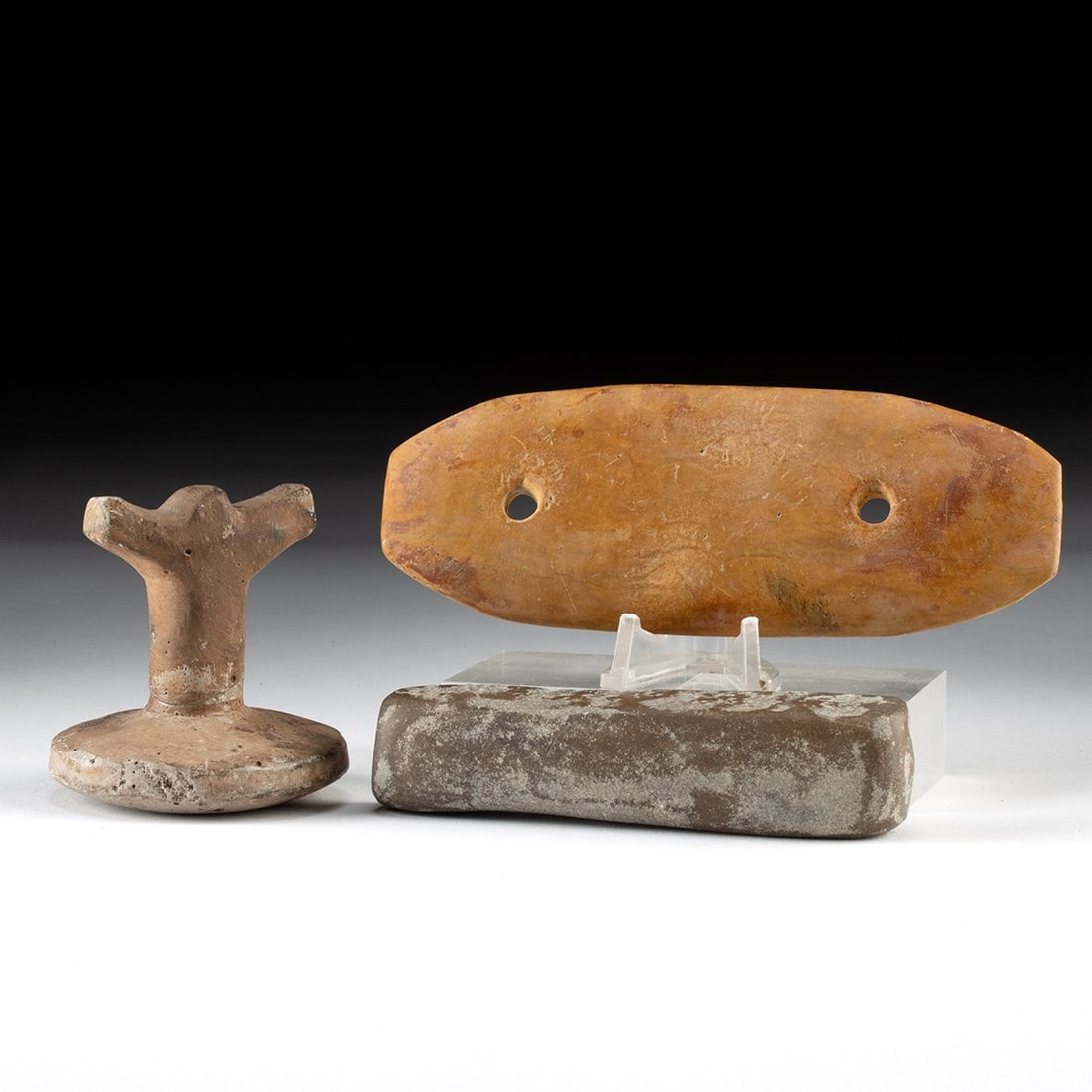 Native American Stone Gorget, Bannerstone Preform & Pottery Trowel Group: Native American, Mississippian and Archaic cultures, ca. 6000 BCE – 1500 CE. A trio of worked-stone and fired-clay implements spanning millennia of Eastern Woodlands craft. The largest is a two-