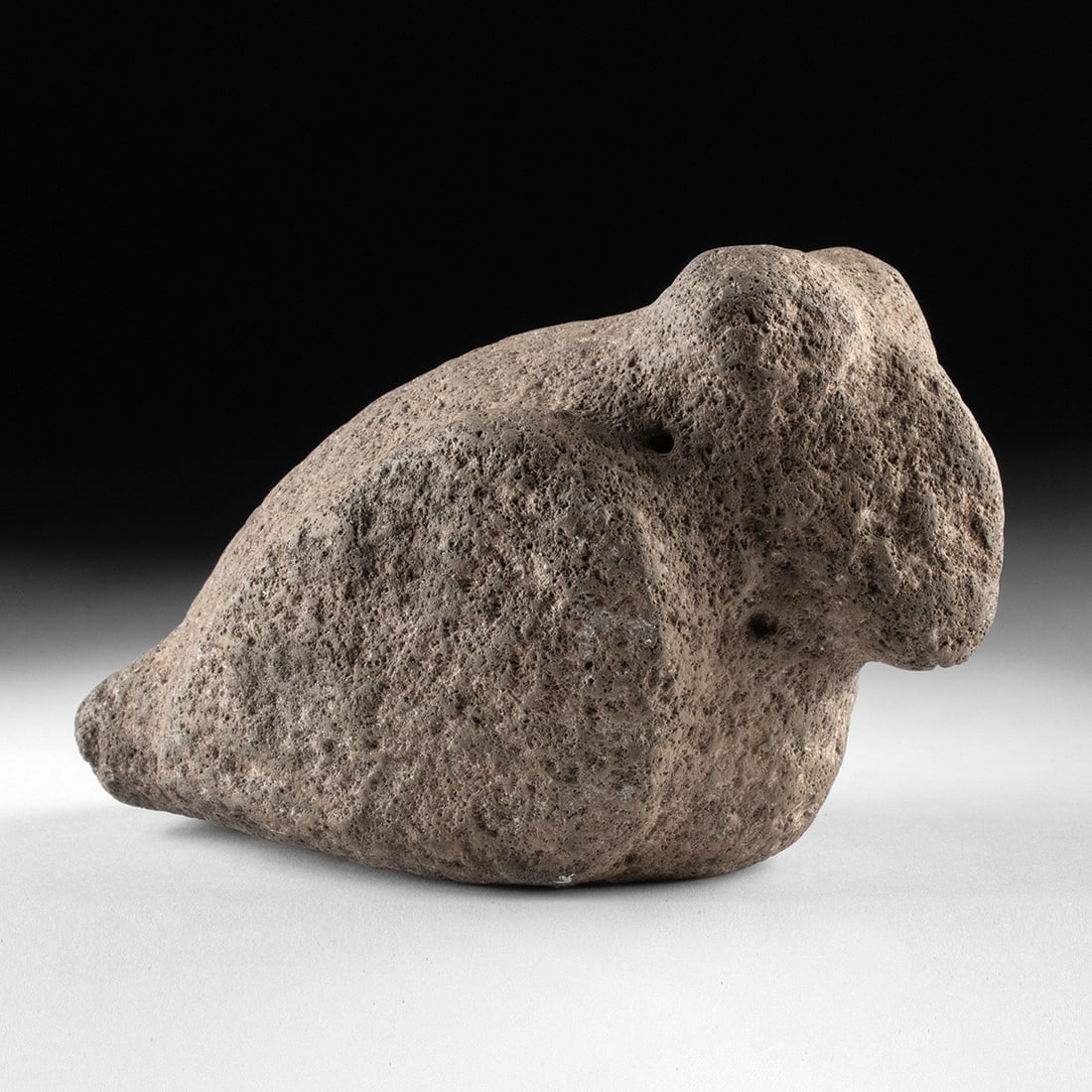 Mississippian Basalt Pop-Eyed Birdstone Effigy: Native American, Mississippian culture, ca. 800–1600 CE. A compact, sculpturally distilled basalt effigy carved in the form of a perched bird, its body reduced to a sleek, river-smoothed mass fr