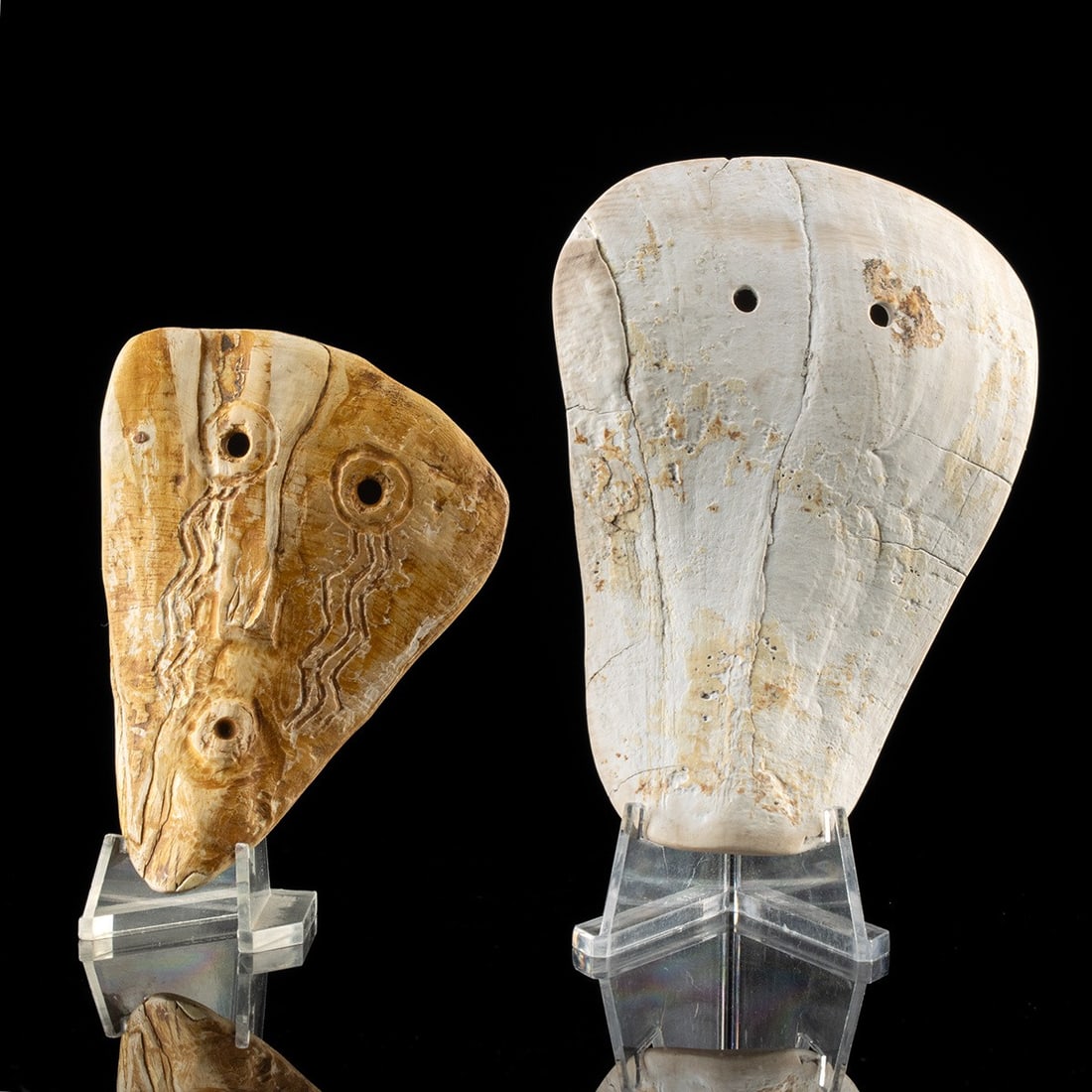 Mississippian Carved Conch Shell Maskettes - Weeping Eye, Pair: Native American, Mississippian culture, ca. 1000–1500 CE. A pair of carved marine shell maskettes from the Mississippian world, each pared down to the essentials of a human face. The smaller exa