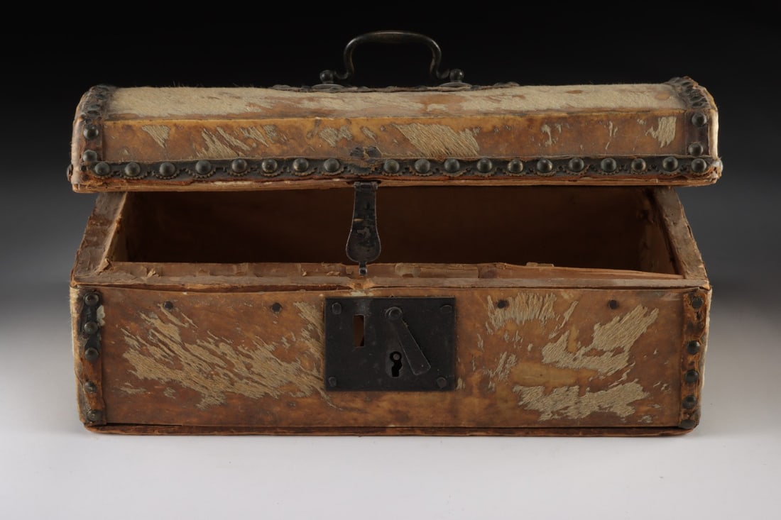 18th C. Spanish Colonial Hide-Covered Document Box - Iron Lock & Brass Tacks: Spanish Colonial, Americas, ca. 1700–1799 CE. A domed-lid casket of pine sheathed in hair-on hide, its rawhide skin worn to a mottled chamois and umber surface where the original pelt has rubbed
