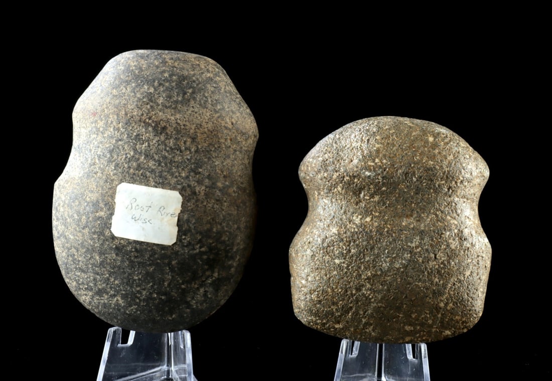 Two Archaic Native American Full Groove Axe Heads: Native American, United States, Midwestern region, Archaic period, ca. 3000 BCE to 1000 BCE. Two full-groove axe heads with rounded butt ends and smoothly polished cutting edges from prolonged use. On