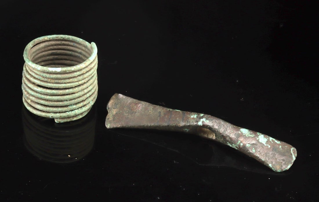 Bronze Age Copper Votive Axe Head & Brass Hair Coil: Central Europe, Bronze Age, ca. 1200 to 800 BCE. A fascinating lot of two personal and ritual objects from the Bronze Age, illustrating both the spiritual and ornamental aspects of early European soci