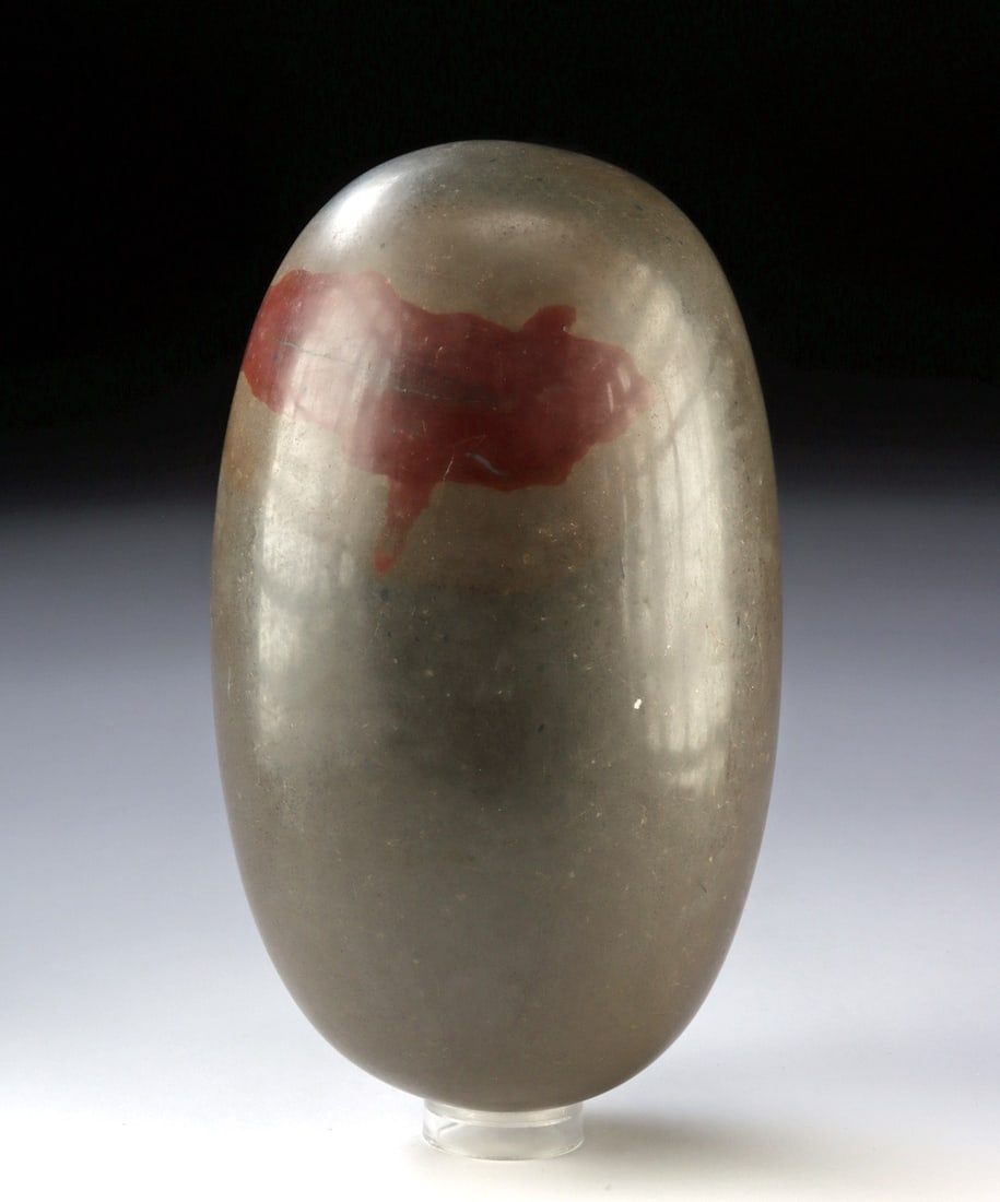 Hindu Shaivite Polished Stone Shiva Linga, Svayambhu Type: Ca. 1850 - 2000 CE. South Asia, India, Hindu, Shaivite Tradition, Narmada River region. A Shiva linga of polished dark gray stone, this sacred object embodies one of the most enduring and cosmological