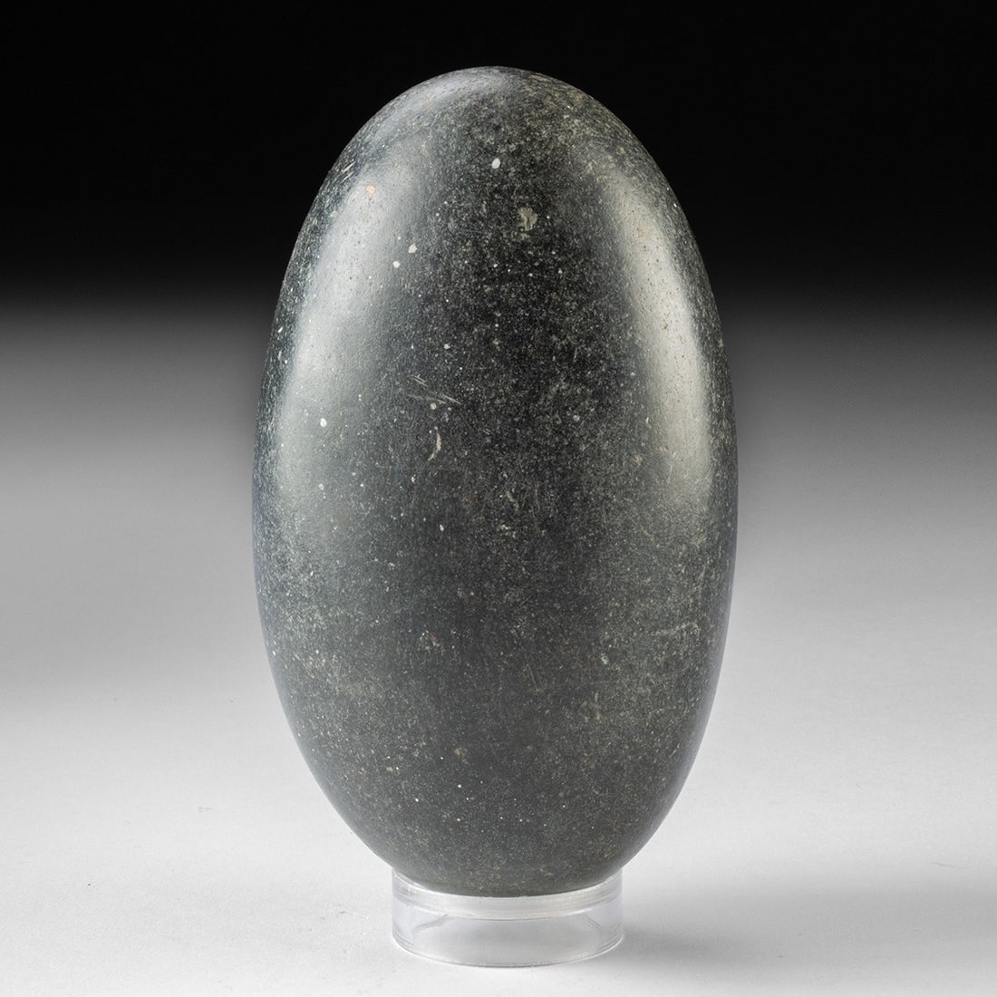Indian Stone Shiva Lingam - Naturally Polished Narmada Ovoid: South Asia, India, Hindu tradition. A smooth ovoid of dark cryptocrystalline stone, its surface burnished to a soft sheen by the relentless current of the Narmada River. Egg-shaped and dense, the form