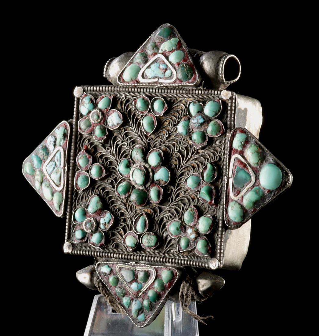 Tibetan Brass & Turquoise Gau Prayer Box Pendant: Central Asia, Tibet, ca. 19th to mid-20th century CE. A pendant container known as a gau or prayer box, crafted from brass with turquoise stone inlays and silver-brass filigree wires spiraling outward