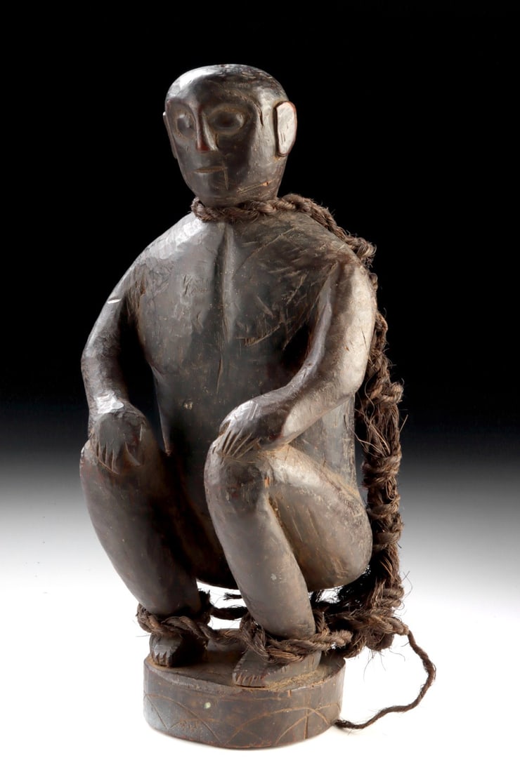 Dayak Wood Bound Captive Figure w/ Horse Hair Rope: Southeast Asia, Borneo, Dayak culture, ca. 20th century CE. A compelling Dayak wood sculpture depicting a squatting, nude captive bound tightly with a rope woven from horse hair, the figure rendered w