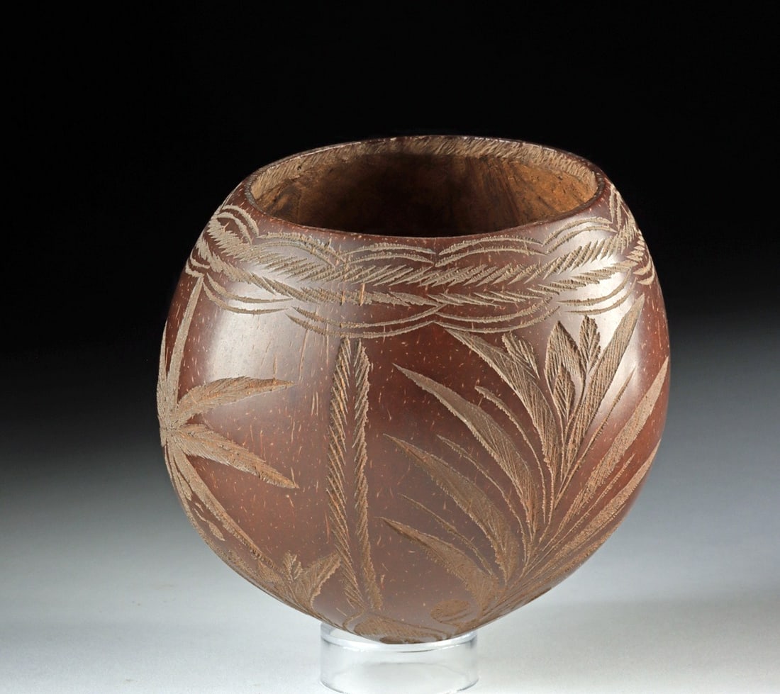 19th C. Carved Coconut Vessel - Palm Tree Tropical Scene: Tropical Americas or Pacific, ca. 1850–1920 CE. A whole coconut transformed into a sculptural curio, its dark husk incised with a continuous frieze of palm trees whose feathered fronds arc acros
