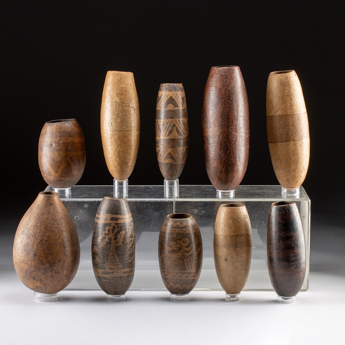 Ten Andean Painted Gourd Drinking Vessels: South America, Ecuador / Peru, ca. early-to-mid 20th century. A collection of ten dried and hollowed gourd vessels in a range of ovoid and elongated forms, their natural surfaces ranging from pale tan