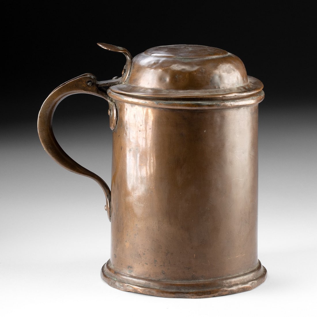 18th C. Copper Lidded Tankard - Domed Hinged Cover: Western Europe / United States, ca. 18th to 19th century CE. A cylindrical copper tankard rising from a stepped, moulded foot to a rolled rim, its warm patinated surface flecked with age and honest us