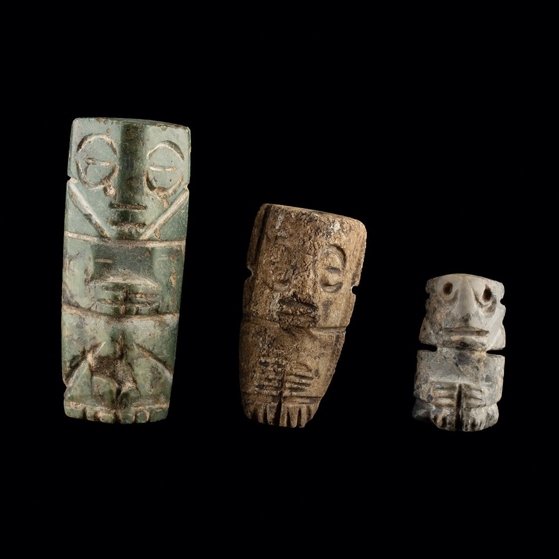 Mixtec Stone Penate Figures - Group of Three Amulets: Pre-Columbian, Mexico, Mixtec culture, ca. 1200–1521 CE. A group of three Mixtec carved stone pendant figures with schematic incised features, including brow lines, sunken eyes, and arms drawn a