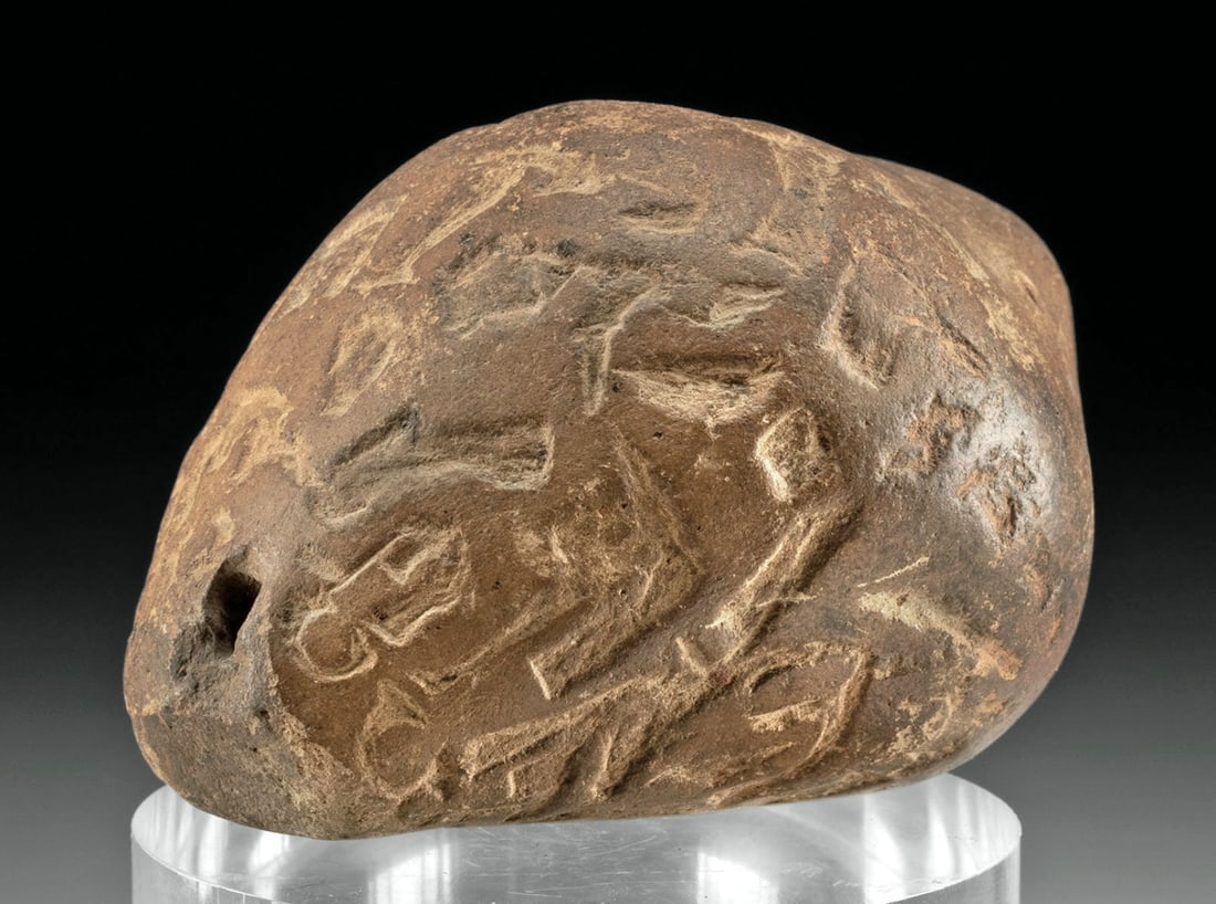 Ecuadorian Pottery Shell Effigy Ocarina, Ex-Gibran: Pre-Columbian, Ecuador, ca. 5th to 15th century CE. A pottery ocarina whistle in the form of a shell with etched zoomorphic and figural motifs. The artisan even molded the interior spiral, and the mou
