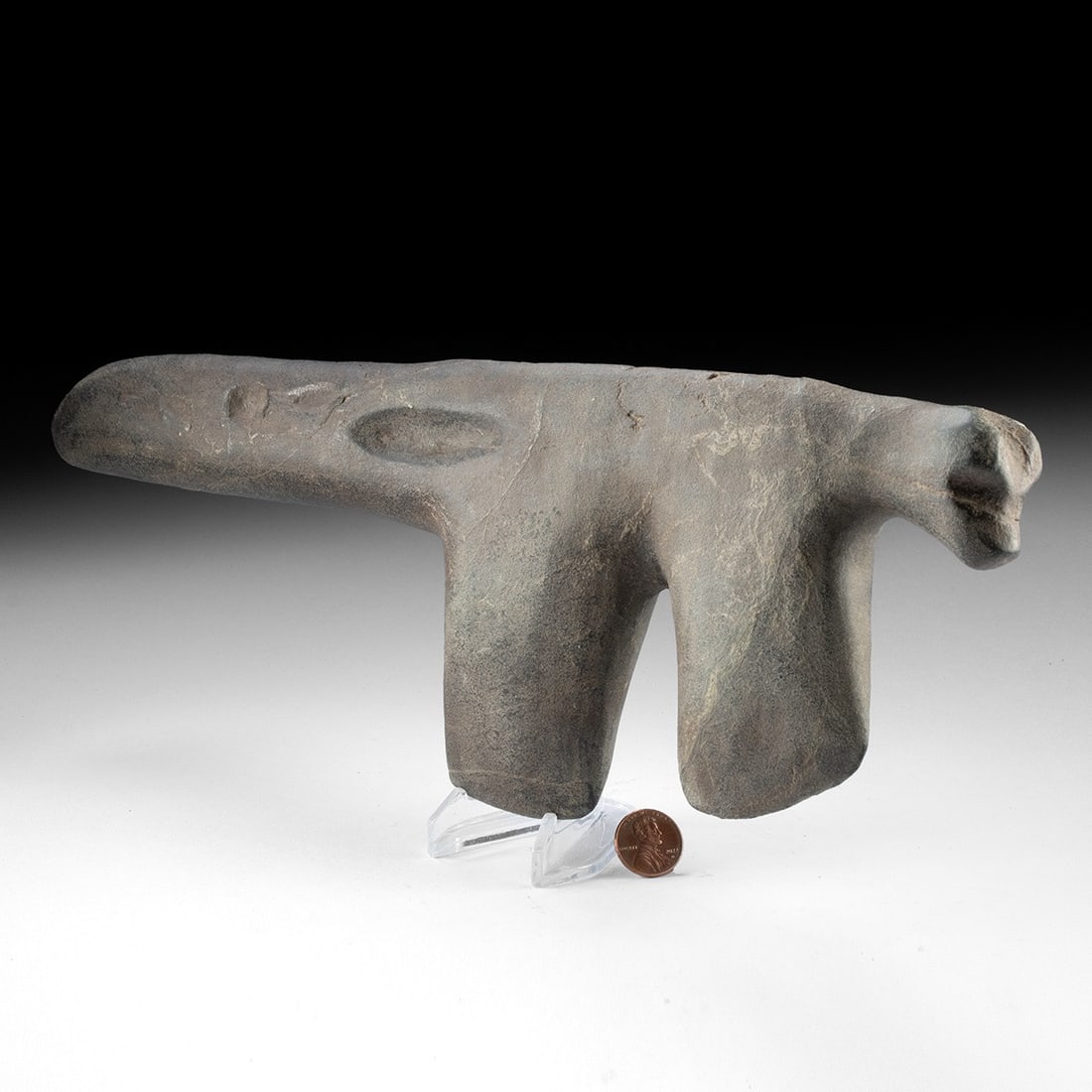 Woodland Greenstone Double-Headed Ceremonial "Slave Killer" Axe w/ Effigy Canine Head: Native American, Pacific Northwest Coast, ca. 1000 BCE – 1000 CE. A monolithic greenstone club carved as a single mass into two opposed hammer-like heads flanking a long central shaft, its worke