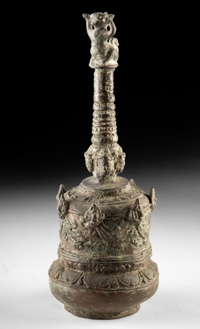 Sumatran Kerinchi Brass Ghanta Bell w/ Singa Finial: Southeast Asia, Indonesia, Sumatra, Kerinchi culture, ca. early to mid-20th century CE. A hand-held brass ghanta (ghenta) bell crowned by a rearing singa, a feline-like guardian whose uplifted pose gi