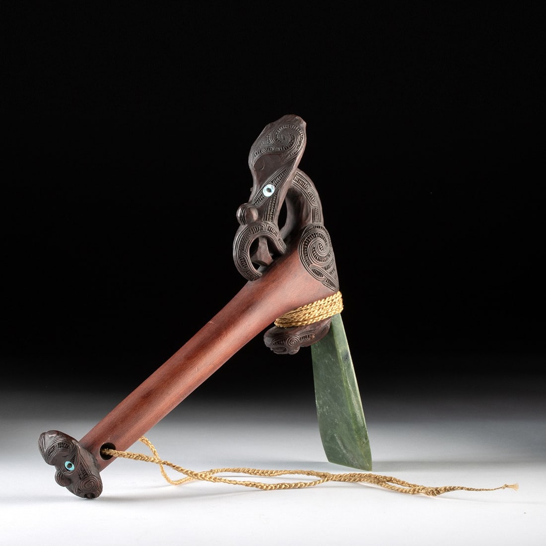 Maori Toki Poutangata - Nephrite & Nacre Ceremonial Adze: Oceania, New Zealand, Maori, ca. 1970–2020 CE. A ceremonial adze, or toki poutangata, its polished pounamu (nephrite jade) blade lashed with braided fiber cord to a richly carved hardwood haft. 