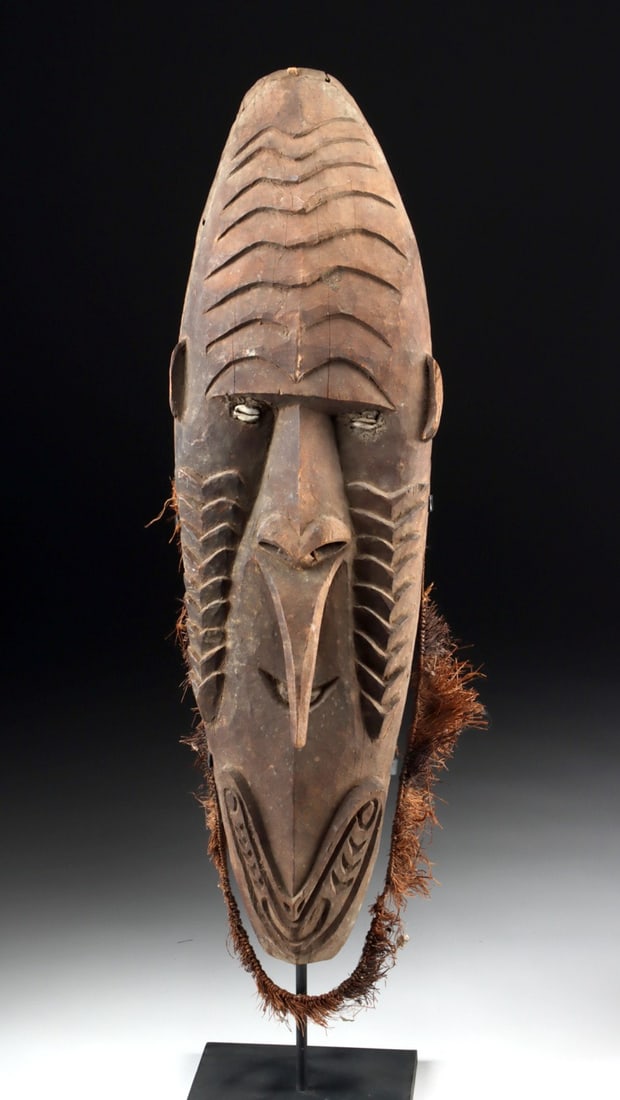 Papua New Guinea Iatmul Mei Mask w/ Cowrie Shell Eye: Oceania, Papua New Guinea, Iatmul People, Middle Sepik River, ca. 20th century CE. A commanding and elongated Mei mask from the Iatmul people of the Middle Sepik River, carved from a single piece of w