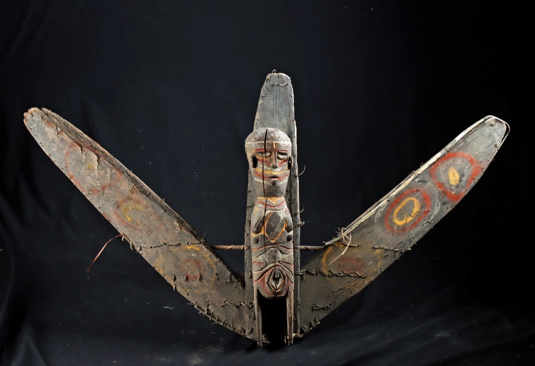 Papua New Guinea Wood War Canoe Prow Shield: Oceania, Papua New Guinea, Sepik River region, ca. early to mid-20th century CE. A canoe prow ornament shield, hand-carved from wood and painted with natural ochre pigments, featuring a boldly rendere