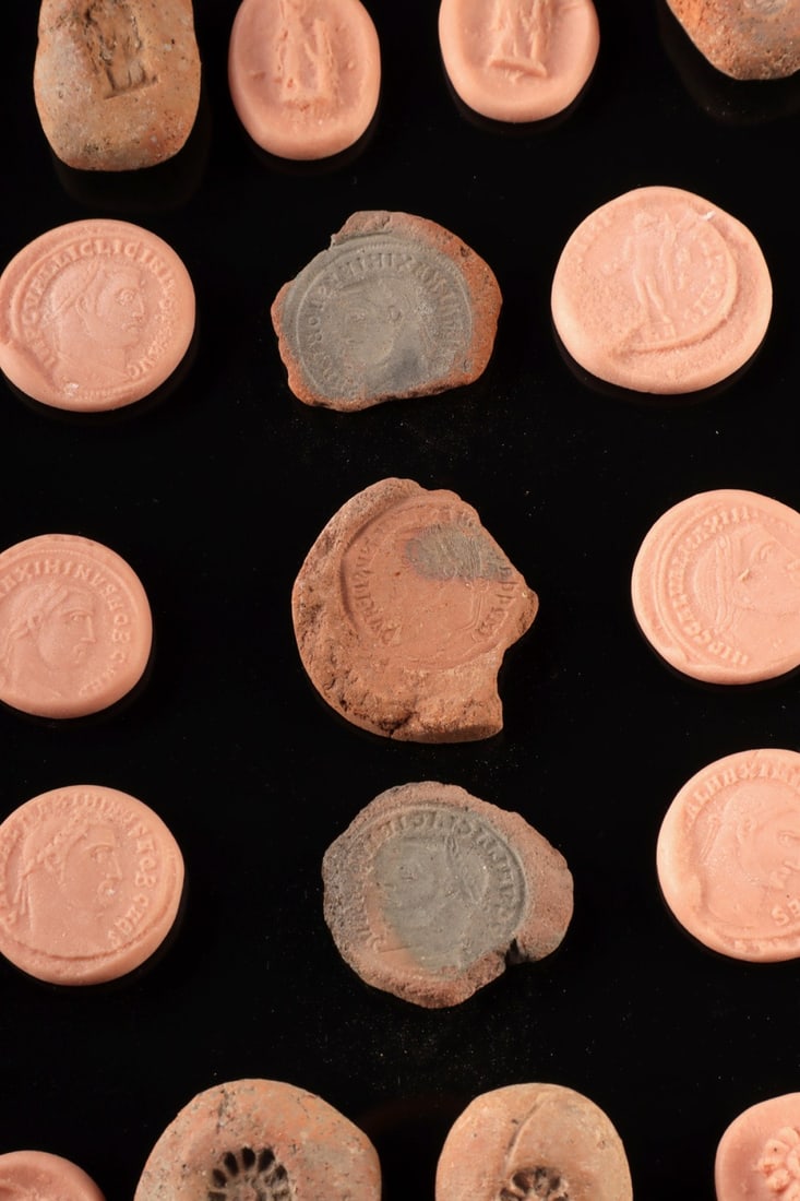 Egyptian Faience Amulet & Roman Coin Molds, 19 Pieces: Egypt, New Kingdom to Romano-Egyptian period, ca. 1550 BCE to 300 CE; Roman, Imperial period, ca. 3rd to 4th century CE. A compelling study group of nineteen objects spanning two ancient manufacturing