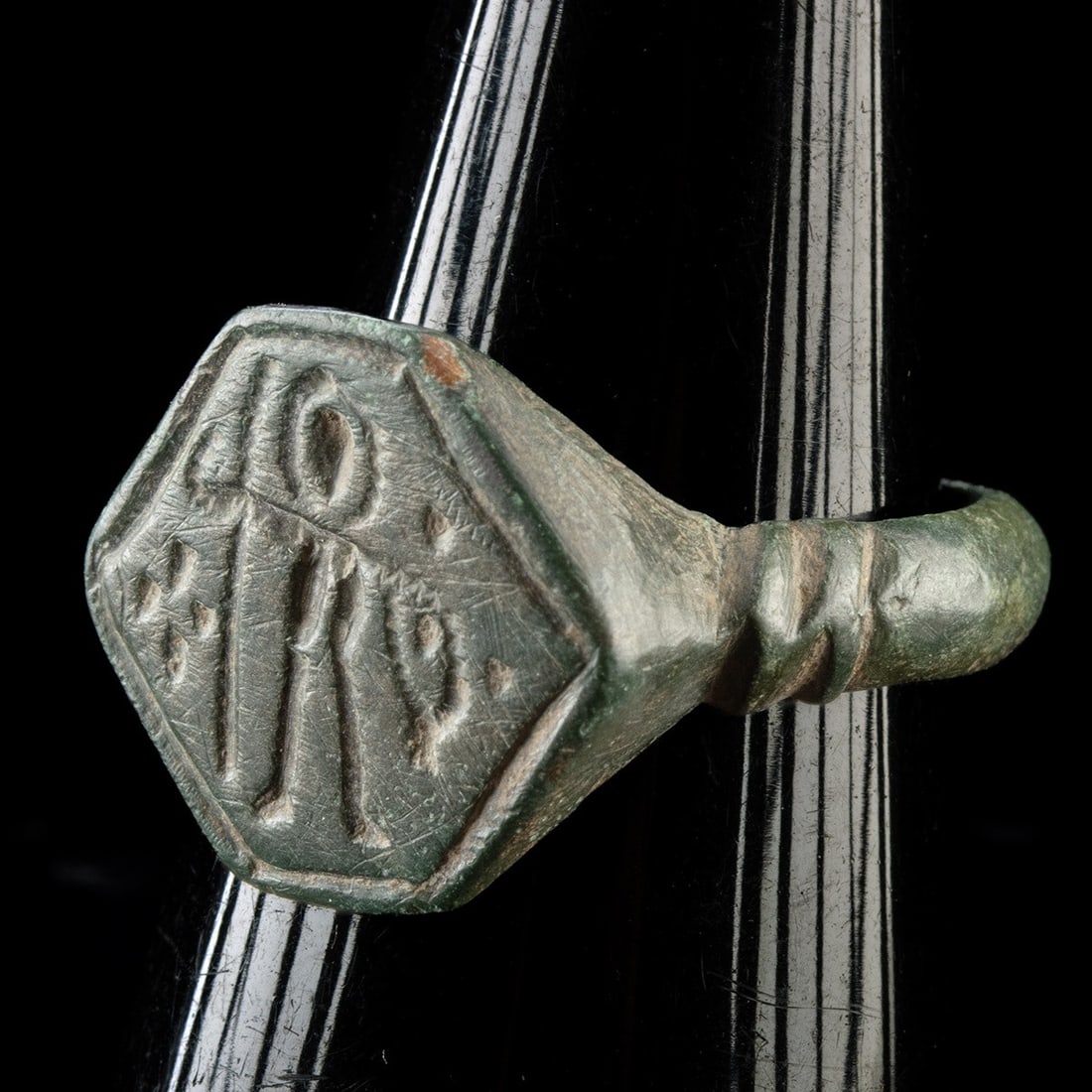 Roman-Medieval Bronze Signet Ring - Engraved Hexagonal Bezel of Standing Warrior: Europe, Roman to Medieval era, ca. 400–1400 CE. A bronze men's signet ring with a hexagonal bezel engraved with a standing figure, possibly a warrior or saint, flanked by pellets and linear devi
