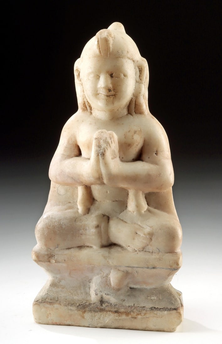 18th C. Indian Marble Devotional Deity Figure: Central Asia, India / Tibet, ca. 18th to 19th century CE. A carved marble figure seated cross-legged upon a tiered pedestal, shown with hands clasped together before the chest in a gesture of reverenc