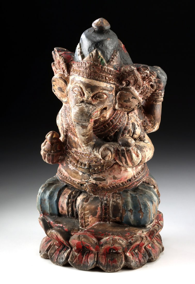 Indian Carved Wood Ganesh in Lotus Pose, Four Arms: South Asia, India, ca. 20th century CE. A richly animated vision of divine presence, this carved wood sculpture depicts Ganesh seated in lotus position, embodying wisdom, abundance, and the gentle hum