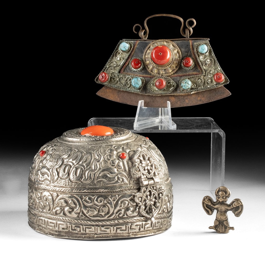 Tibetan Nickel Brass Box, Flint Striker Pouch & Garuda Pendant: Central Asia, Tibet, ca. 1850–1950 CE. A repousse lidded box, a flint striker purse, and a small Garuda. The largest is a domed circular box, its repousse surface densely chased with scrolling f