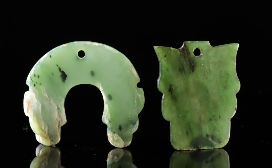 19th C. Chinese Nephrite Jade Pendants (Yupei): East Asia, China, Qing Dynasty, ca. 19th century CE. A pair of nephrite jade pendants known as yupei, crafted from thin panels. One pendant is shaped like a maskette or vessel silhouette, while the ot