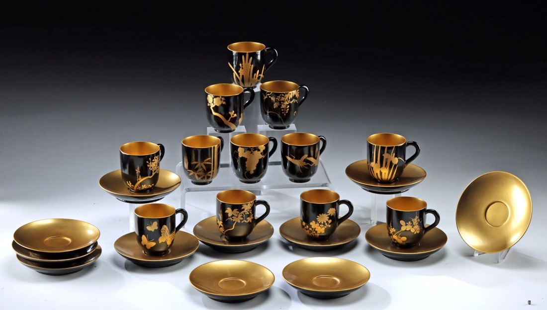 Gorgeous Japanese Gold Maki-e Lacquer Teacup Set, 24pcs: East Asia, Japan, Showa era, ca. mid-20th century CE. A gorgeous set of lacquered and gilt wood tea cups and saucers, each cup and saucer meticulously finished with a glossy black lacquer exterior and