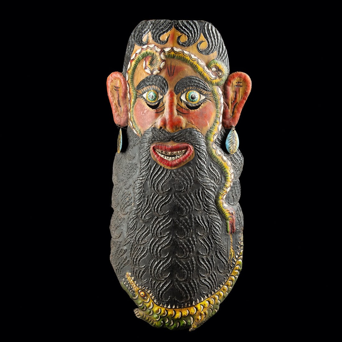 Large Mexican Polychrome Metal Festival Barbone Mask: Latin America, Mexico, Guerrero, ca. mid to late 20th century CE. A large polychrome iron mask depicting a bearded man, painted in vivid green, yellow, red, and black. The lively face features a volum