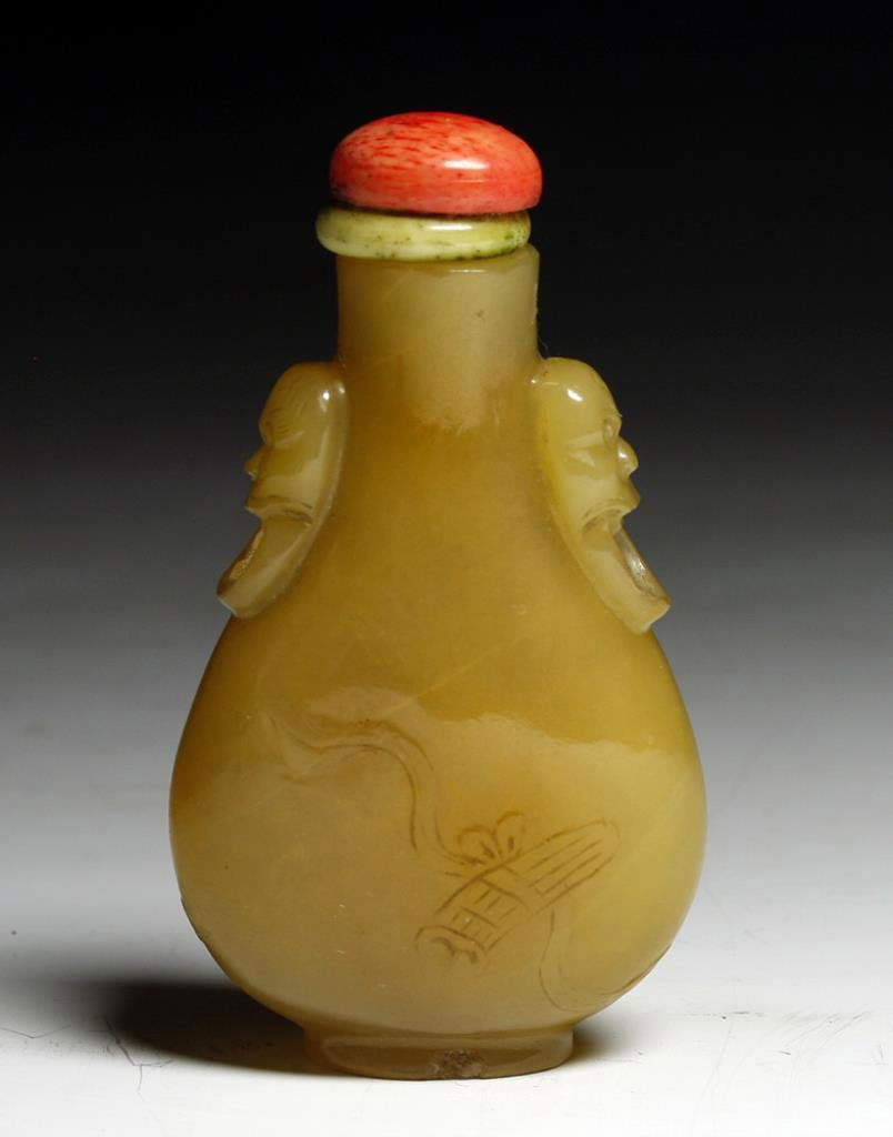 Antique Chinese Agate Snuff Bottle, Tao Masks: Starts at $50 China, Early 20th Century. A very fine snuff bottle carved from golden agate, Tao masks on each side. Stone stopper and bone spoon. 2-5/8"H Provenance: Ex-Sarkisian collection, acquired