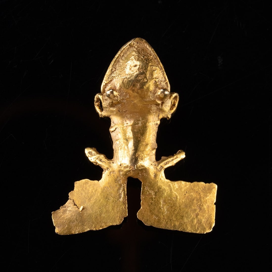 Diquis Tumbaga Frog Pendant - Lost-Wax Cast Gold Alloy Amulet: Pre-Columbian, Costa Rica, Diquis, ca. 500–1520 CE. A diminutive frog cast in warm tumbaga, its body reduced to the essentials: a rounded muzzle and beaded eyes, a spine ridged along a compact t