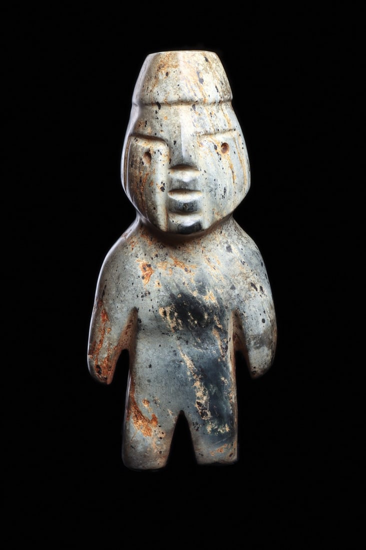 Olmec Serpentine Standing Figure with Banded Headdress, Guerrero: Pre-Columbian, Mexico, Guerrero, Olmec, 600 BCE. A standing figure carved from mottled blue-green serpentine, the stone shot through with dark inclusions and warm ferrous veining. The body is reduced 