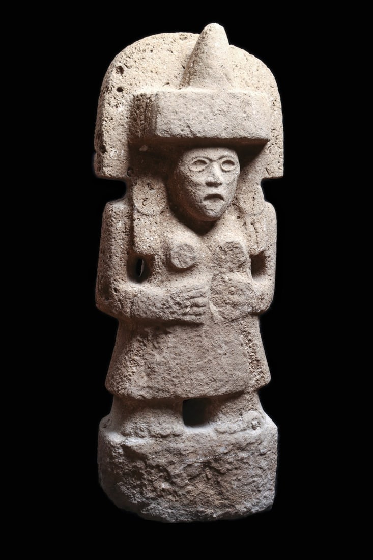 Huastec Stone Female Figure Boundary Marker with Crescent Headdress: Pre-Columbian, Mexico, Northern Veracruz, Huastec culture, ca. 900–1525 CE. A monumental slab figure carved from gray volcanic stone, standing frontally beneath a wide crescent headdress crowned by 