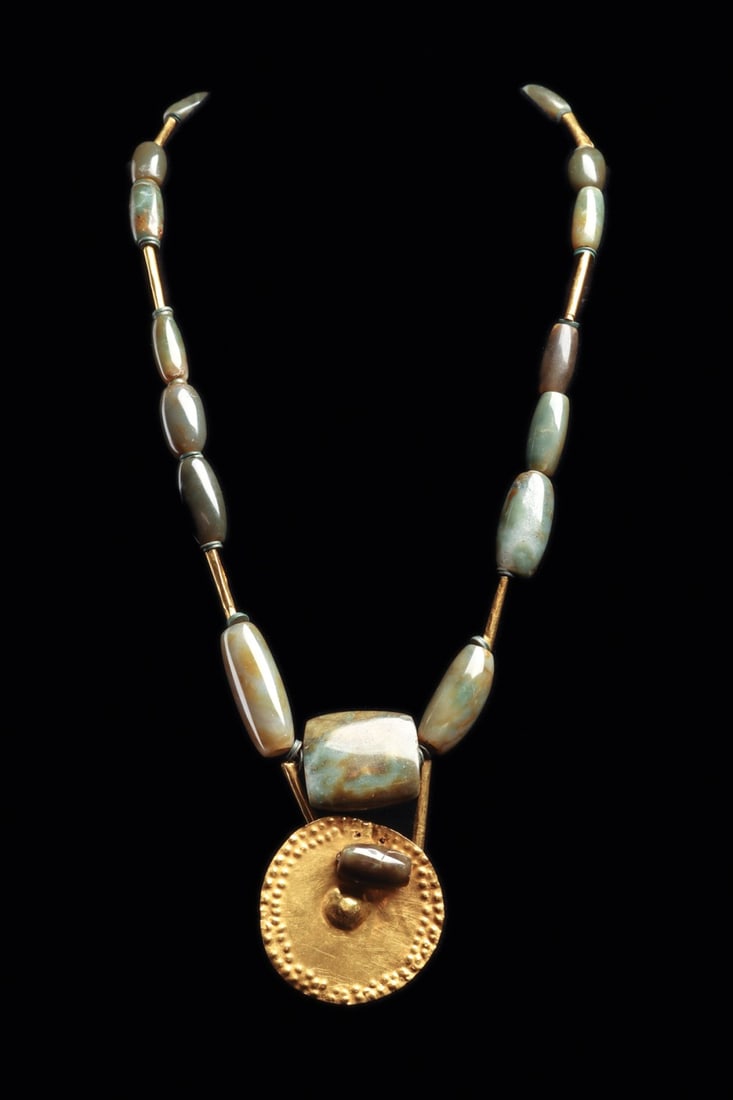 Narino Gold Roundel & Costa Rican Jade Bead Necklace: Pre-Columbian, Costa Rica and Colombia, Narino culture, ca. 500–1000 CE. A single strand of twenty jade beads ranging from pale celadon to blue-green, most elliptically barrel-shaped and drilled