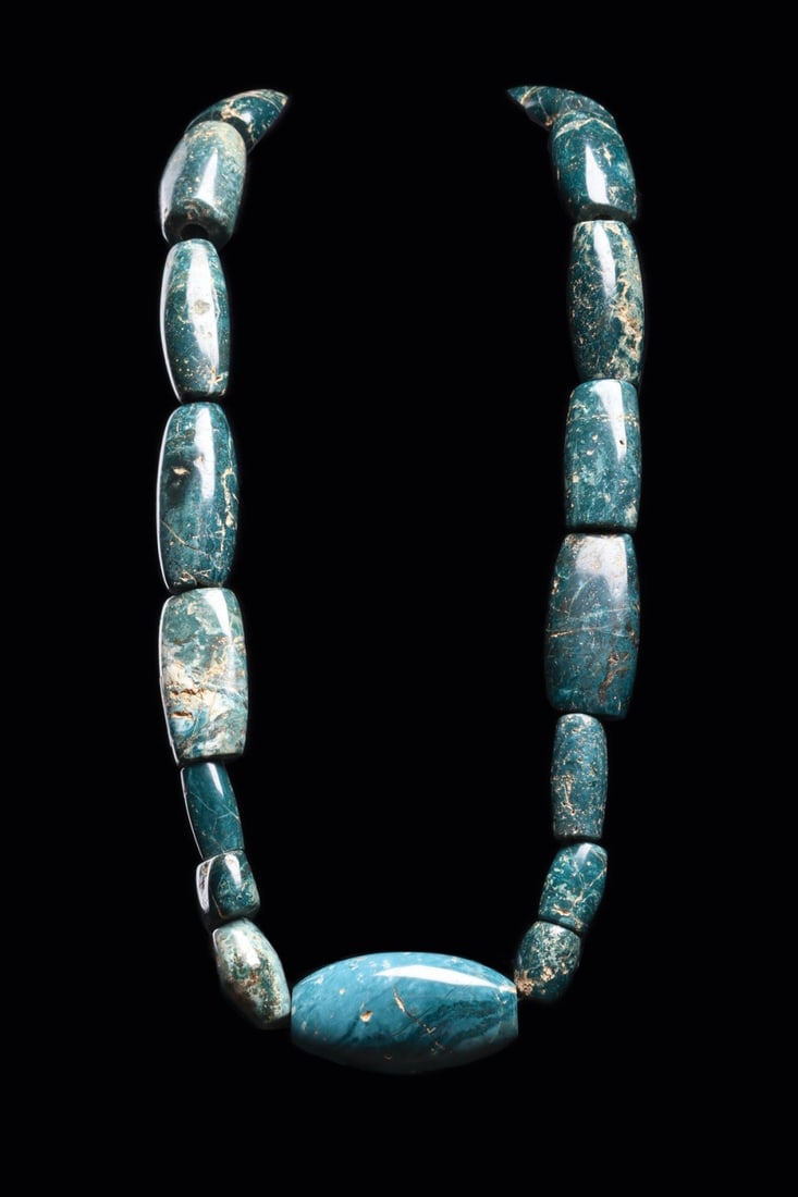 Costa Rican Jade Bead Necklace with Massive Elliptical Beads: Pre-Columbian, Costa Rica, ca. 500–1000 CE. A ribbon of blue-green jade strung as eighteen elliptical beads, twelve of them massive, their long barrel forms swelling toward a single oversized ce